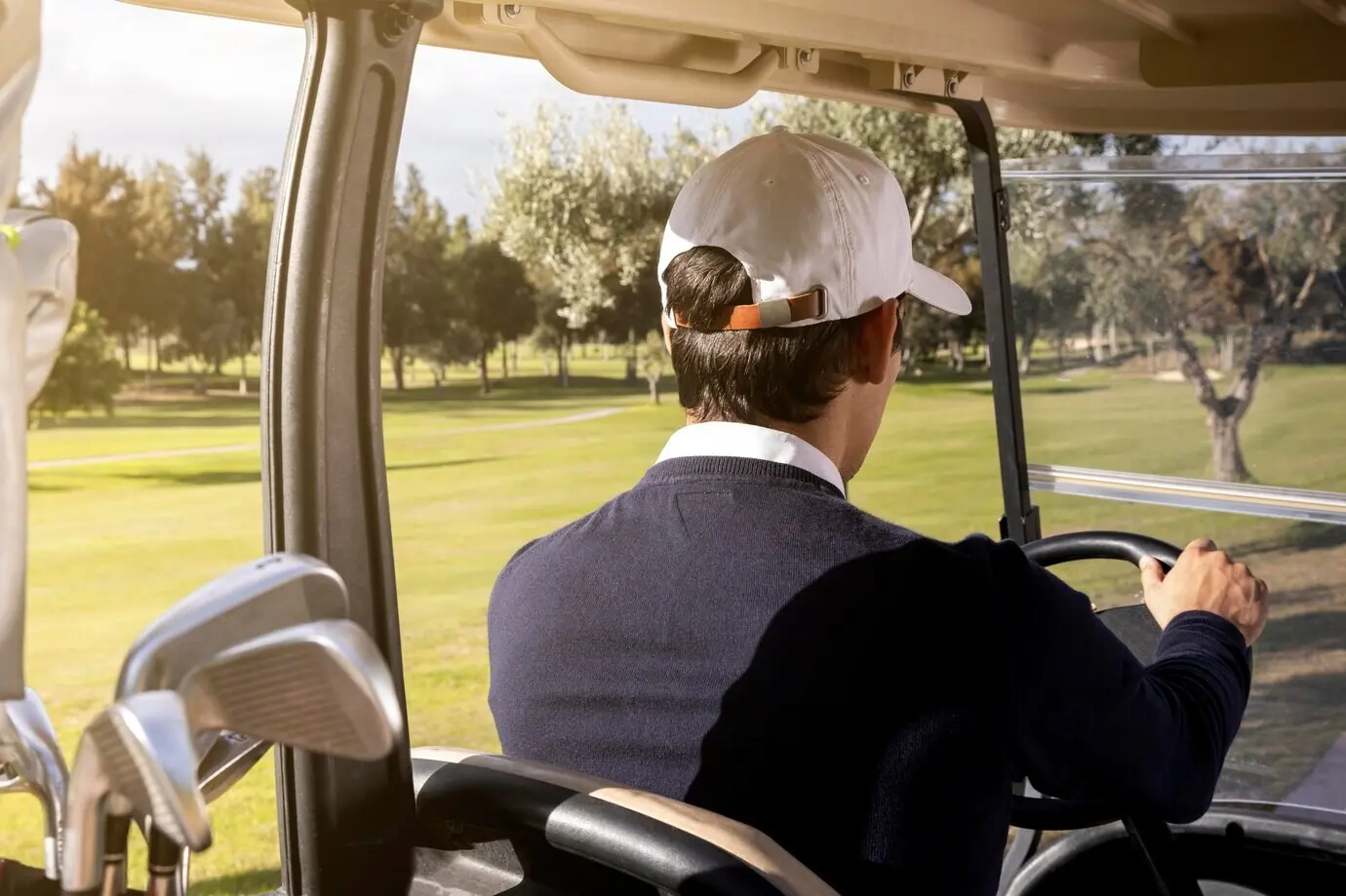 A man driving a golf cart on the field.